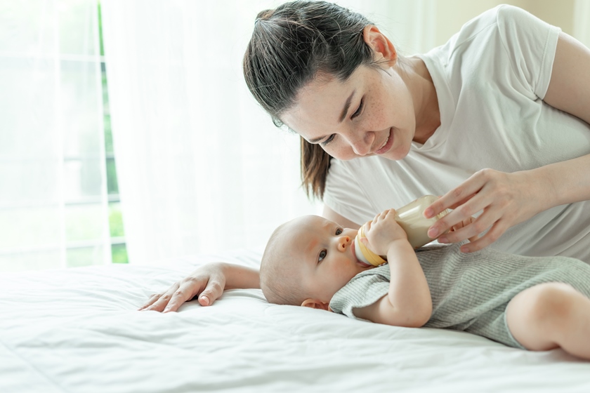 baby-drinking-milk-from-bottle-with-mother-him